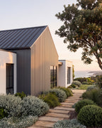 Grey exterior slat panels on a coastal home exterior.