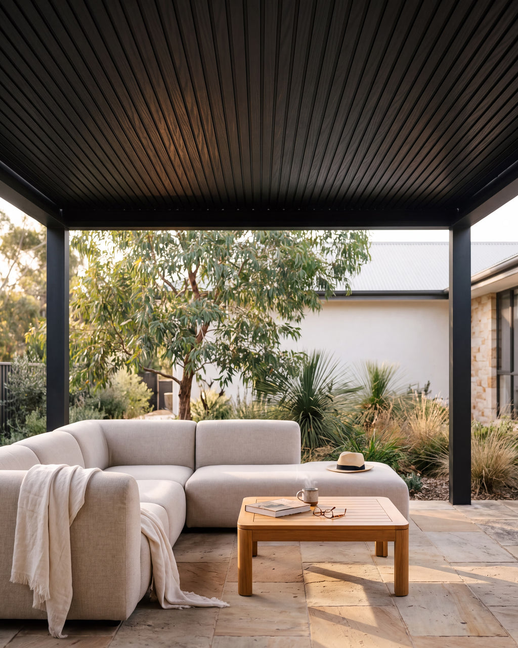 Black composite exterior wall panels lining a covered outdoor pergola.