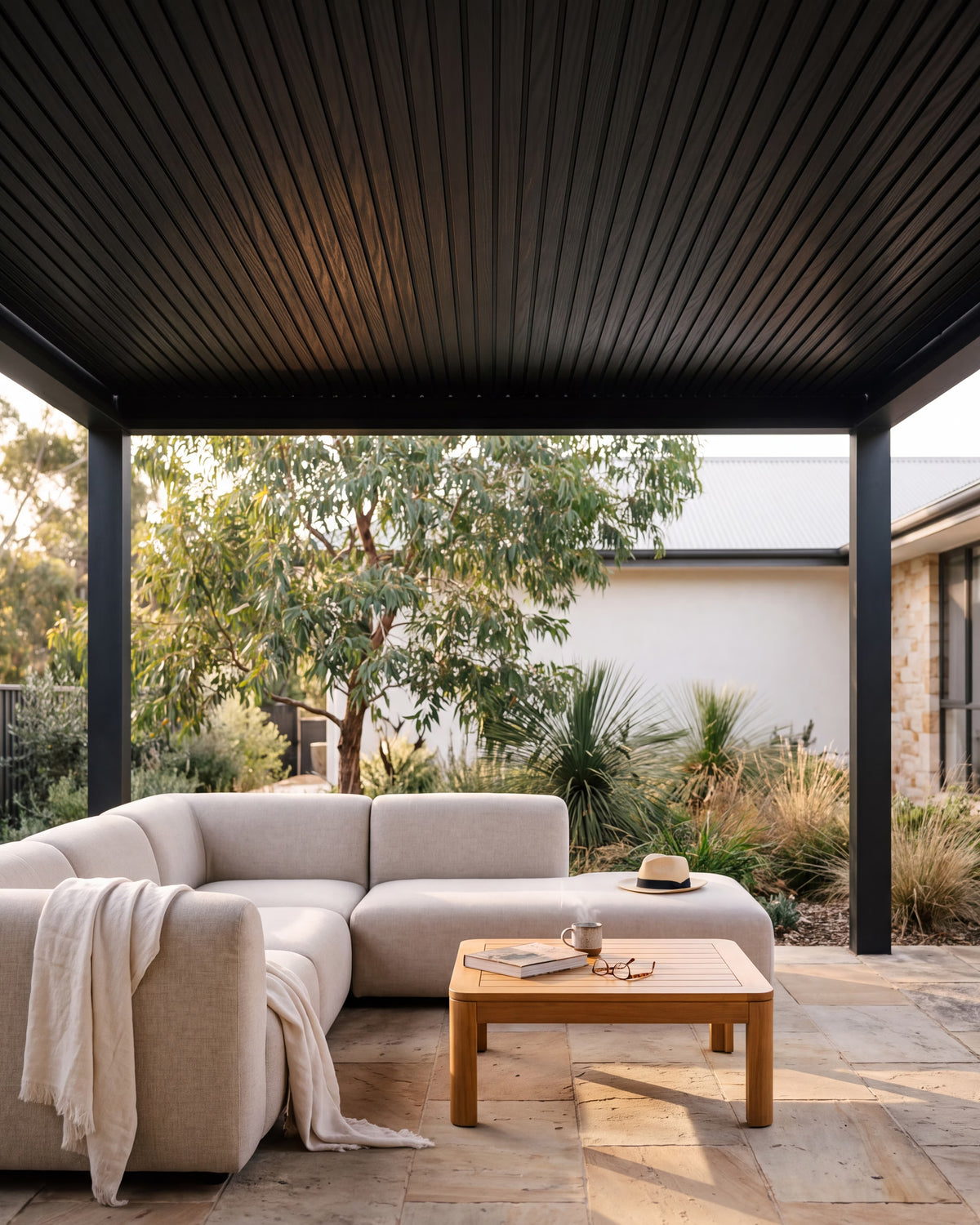 Black composite exterior wall panels lining a covered outdoor pergola.