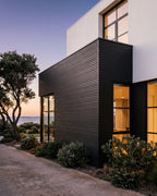 Black vertical slat wall panels on a coastal home exterior.