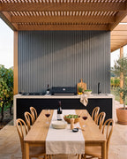 Grey wall panels behind a covered outdoor kitchen.