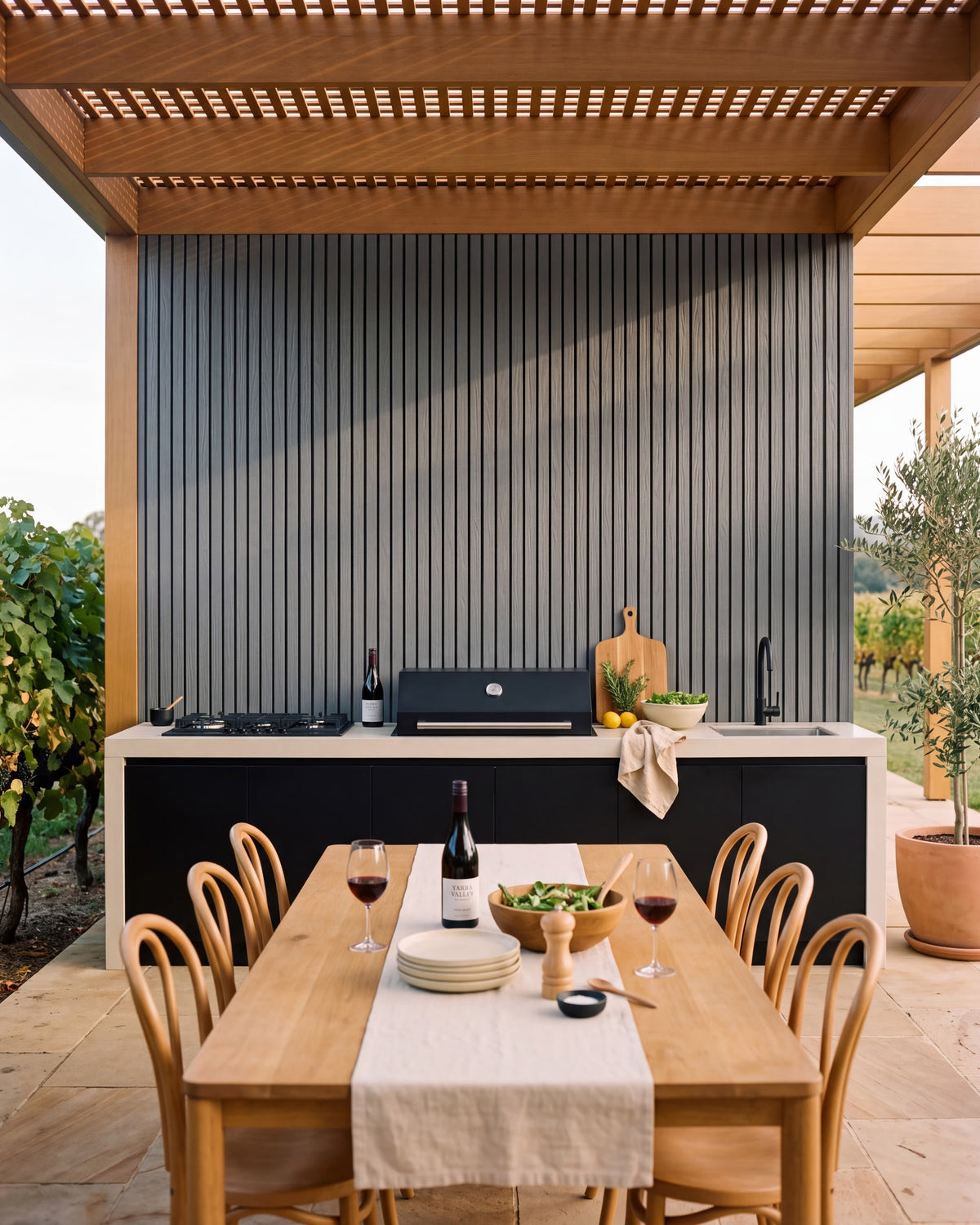 Grey wall panels behind a covered outdoor kitchen.