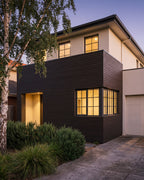 Walnut composite wood wall panels across a modern house facade.
