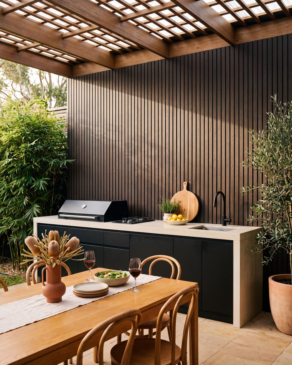 Walnut composite wall panels behind a covered outdoor kitchen.