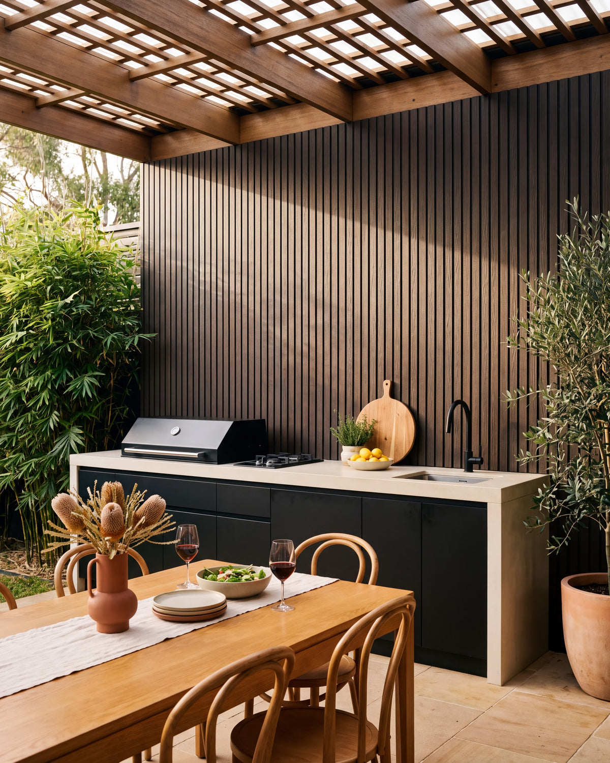 Walnut composite wall panels behind a covered outdoor kitchen.