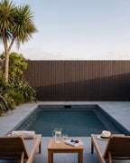 Walnut wood-look composite panels lining a swimming pool fence.